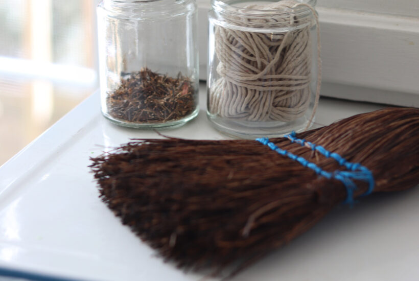 wisk broom, string in a jar on a cabinet shelf